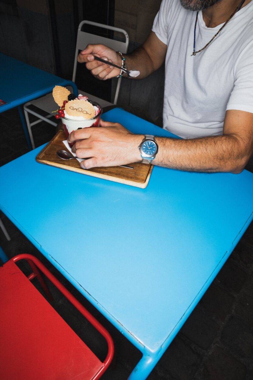 Turan is eating an ice-cream with the octo Roma on the wrist